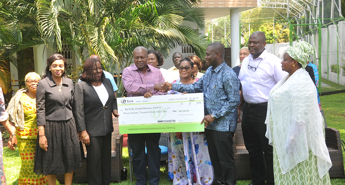  President Mahama presenting a dummy cheque for Gh¢300,000 to Dr Frank Serebour, Head of the Cardiothoracic Unit of the Korle Bu Teaching Hospital. With them are Mrs Lordina Mahama (4th from right), First Lady, Mr Ibrahim Mahama (2nd right), President's brother, and some family members of the President. Picture:  EBOW HANSON  